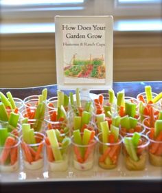 carrots and celery sticks are arranged in small cups with a book on top