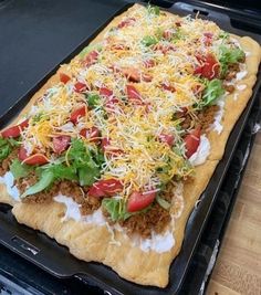 an uncooked pizza sitting on top of a baking pan covered in cheese and toppings