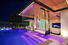 an indoor swimming pool at night with purple lighting