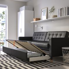 a living room with a couch, coffee table and bookshelf on the wall