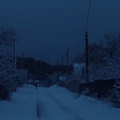 a person walking down a snowy road at night