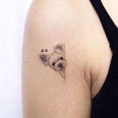 a small dog tattoo on the left shoulder