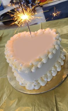 a heart shaped cake with a sparkler on top