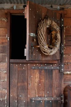 an old wooden door with a wreath on the front and side paneled in metal rivets