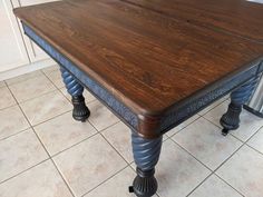 a wooden table sitting on top of a tiled floor