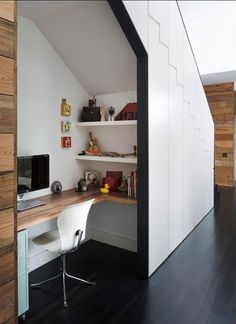 a room with a desk and shelves in it