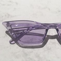 a pair of purple sunglasses sitting on top of a table