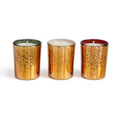 three gold colored candles sitting next to each other