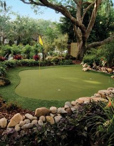 a golf green surrounded by rocks and trees