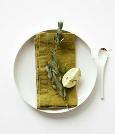 a white plate topped with an apple next to a knife and fork on top of a table