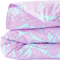 a pink and blue comforter with palm leaves on it