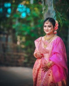 a woman in a pink sari poses for the camera