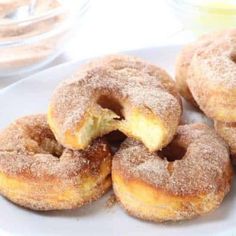 several sugared doughnuts on a white plate