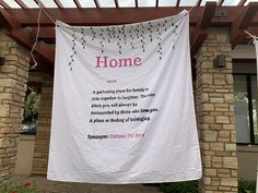 a white banner hanging from the side of a building with words on it that read home