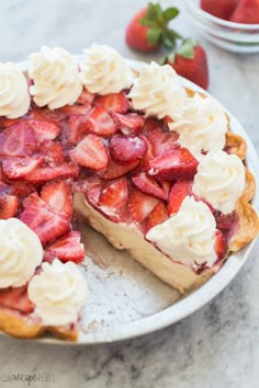 a pie with strawberries and whipped cream on top