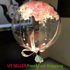 a clear balloon with pink flowers in it