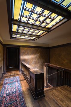 an empty room with wooden floors and stained glass skylight