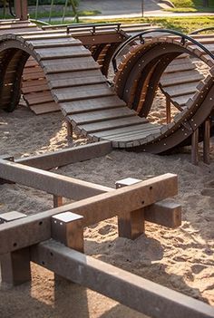 a row of wooden benches sitting on top of a sandy beach