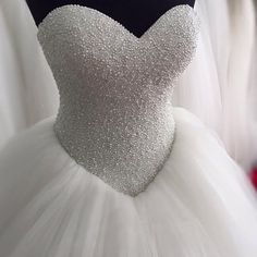 a white wedding dress with beading on it