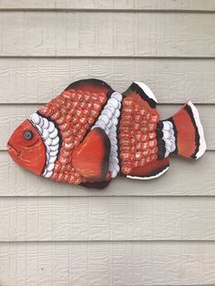 an orange and white clown fish on the side of a house, painted with acrylic paint