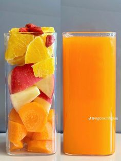 an orange juice in a glass next to a container with sliced fruit on the side