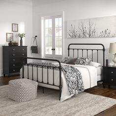 a bedroom with white walls and black furniture