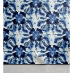 a blue and white wall hanging on the side of a building with an abstract design