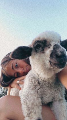 a woman holding a lamb in her arms