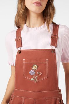 Rust coloured overall with embroidered fresh cottage style floral celebrating spring. A bib & brace style with full length wide cut leg- bib & brace style with adjustable sliders - front bib, leg & back pockets - side buttons - available in toffee Product Code: PGFY099 Embroidered Overalls Flowers, Dungarees Embroidered, Embroidered Overalls Pocket, Floral Dungarees, Cottagecore Dungarees, Colorblock Dress, Rust Color, Knitwear Tops, Shop Swimwear