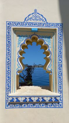 an ornate blue and white window frame with water in the background