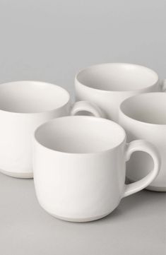 four white coffee cups sitting next to each other