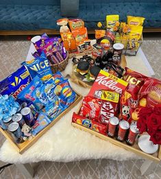 two trays filled with snacks on top of a white rug next to a blue couch