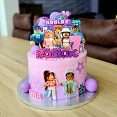 a pink cake with cartoon characters on it