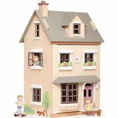 a wooden doll house with two people and a dog in the front window, on a white background