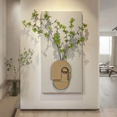 a vase filled with green plants sitting on top of a white wall next to a wooden cutting board