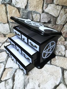 three drawers are stacked on top of each other in front of a stone wall with black and white accents