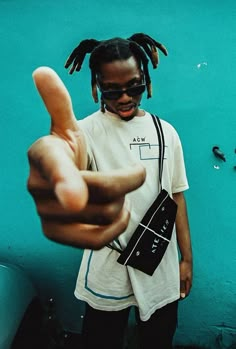 a man with dreadlocks pointing at the camera