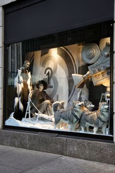 a display window with dogs in sleds and other items on the windowsill