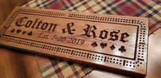 a wooden sign that says, cotton & rose with hearts on it sitting on top of a table