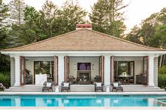 an outdoor pool area with chairs and tables next to the swimming pool in front of it