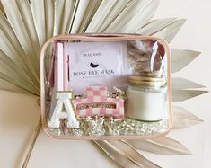 a pink and white box with letters, candles, marshmallows and other items