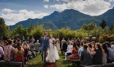 a bride and groom walking down the aisle at their outdoor wedding ceremony in the mountains