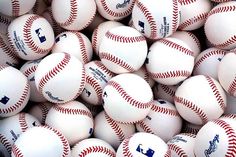 a pile of baseballs with the names of each team and numbers on them in white