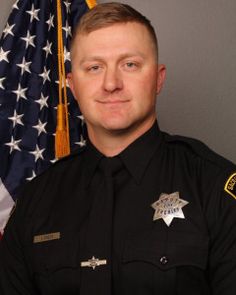 a police officer in front of an american flag