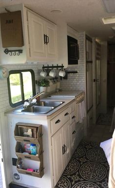 a kitchen area with sink, stove and cabinets in it's own trailer that is parked on the side of the road