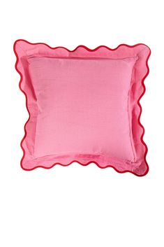 a pink pillow with scalloped edges on a white background and red piping