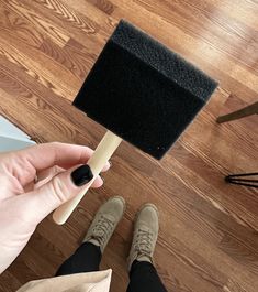 a person is holding a brush on the floor