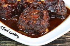 some food is in a white bowl on a table and it looks like meat cooking