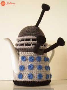 a crocheted tea pot with a blue and white dalen dalen on it