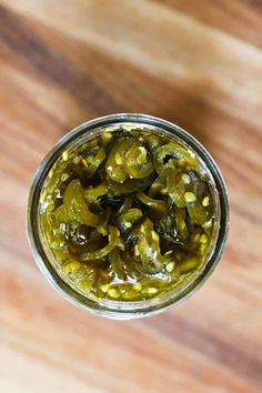 pickles in a glass jar on a wooden table top, ready to be eaten